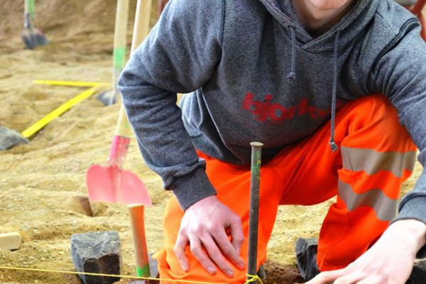 Person beim Verlegen von Pflastersteinen